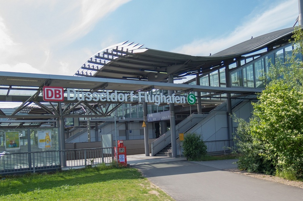 Fernbahnhof am Flughafen Düsseldorf. Wenige Meter dahinter beginnt der Zaun zum Rollfeld.
